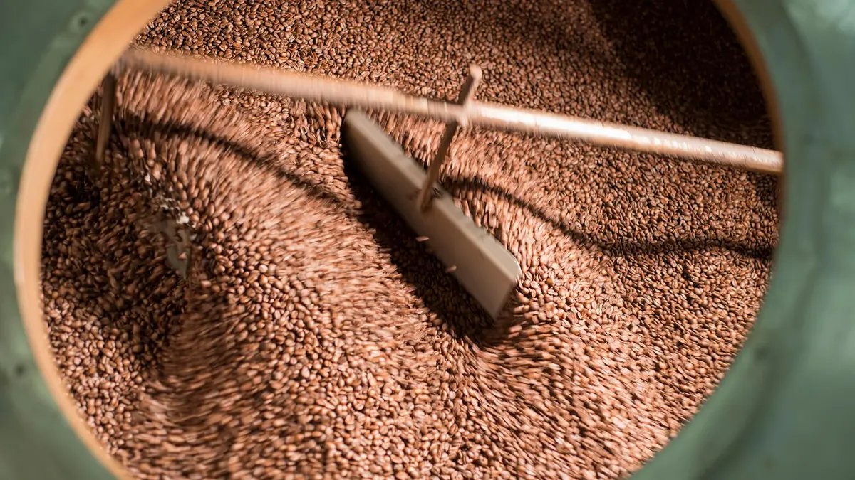 Freshly roasted coffee beans being ground by hand on an Antigua coffee farm and chocolate tour in Guatemala